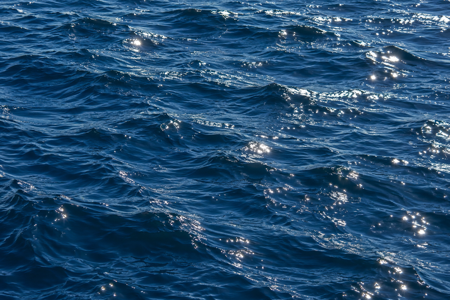 Sunlight reflected on dark blue water